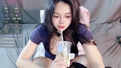 Media: Video of an Asian woman with long black hair, drinking from a clear plastic cup, lying on a bed with white sheets, surrounded by digital stats.