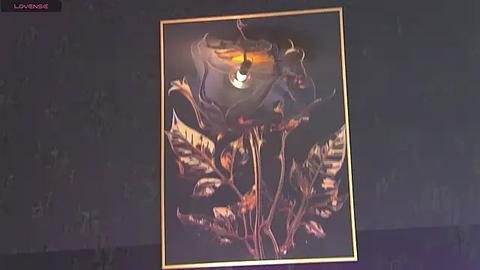 Media: Video of a dark painting featuring a demonic figure with glowing red eyes, surrounded by fiery tendrils and glowing orange flames. The background is black, and the piece is framed with a thin gold border.